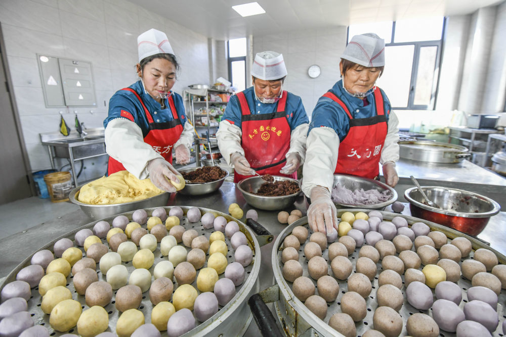 ↑1月13日,工人在河北省遵化市娘娘庄镇一家面食加工厂包制黏饽饽。新华社发(刘满仓摄)