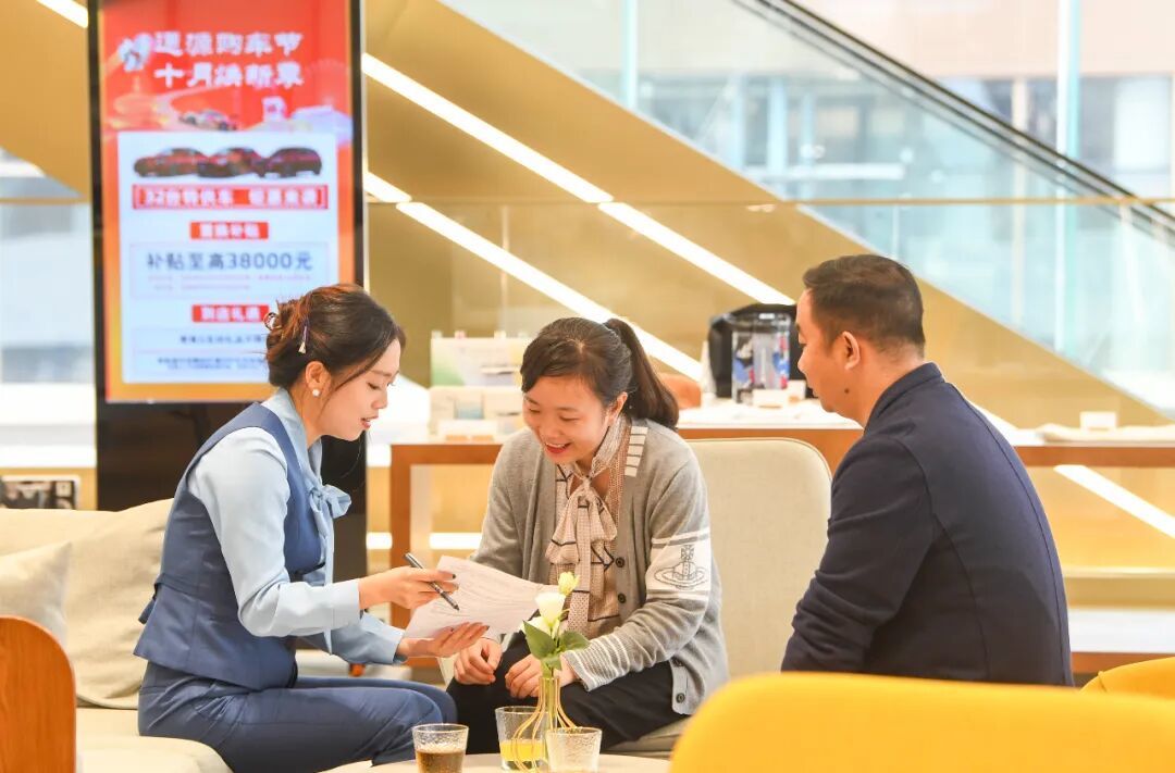 一家4S店的工作人员为消费者介绍购车补贴相关政策/新华社记者王全超 摄