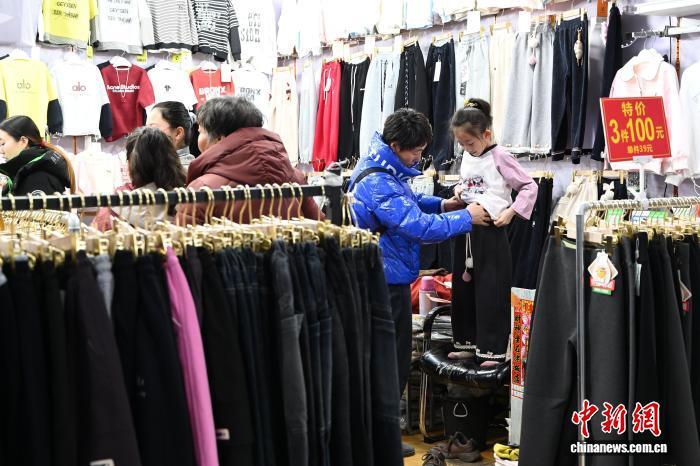 家长为儿童选购裤子。　中新网记者 刘文华 摄