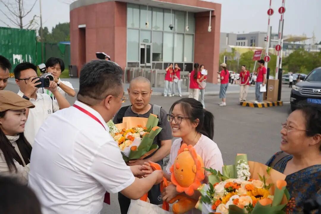 报到现场 学校老师为蒋贤芳“母女”送上鲜花 图据四川师范大学