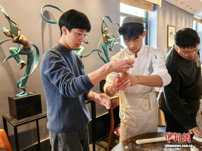 1月22日,台胞青年跟兰州牛肉面师傅学习拉面技法。闫勃轩 摄