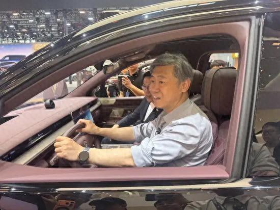 李稻葵在北京车展上试车。国是直通车 陈昊星 摄