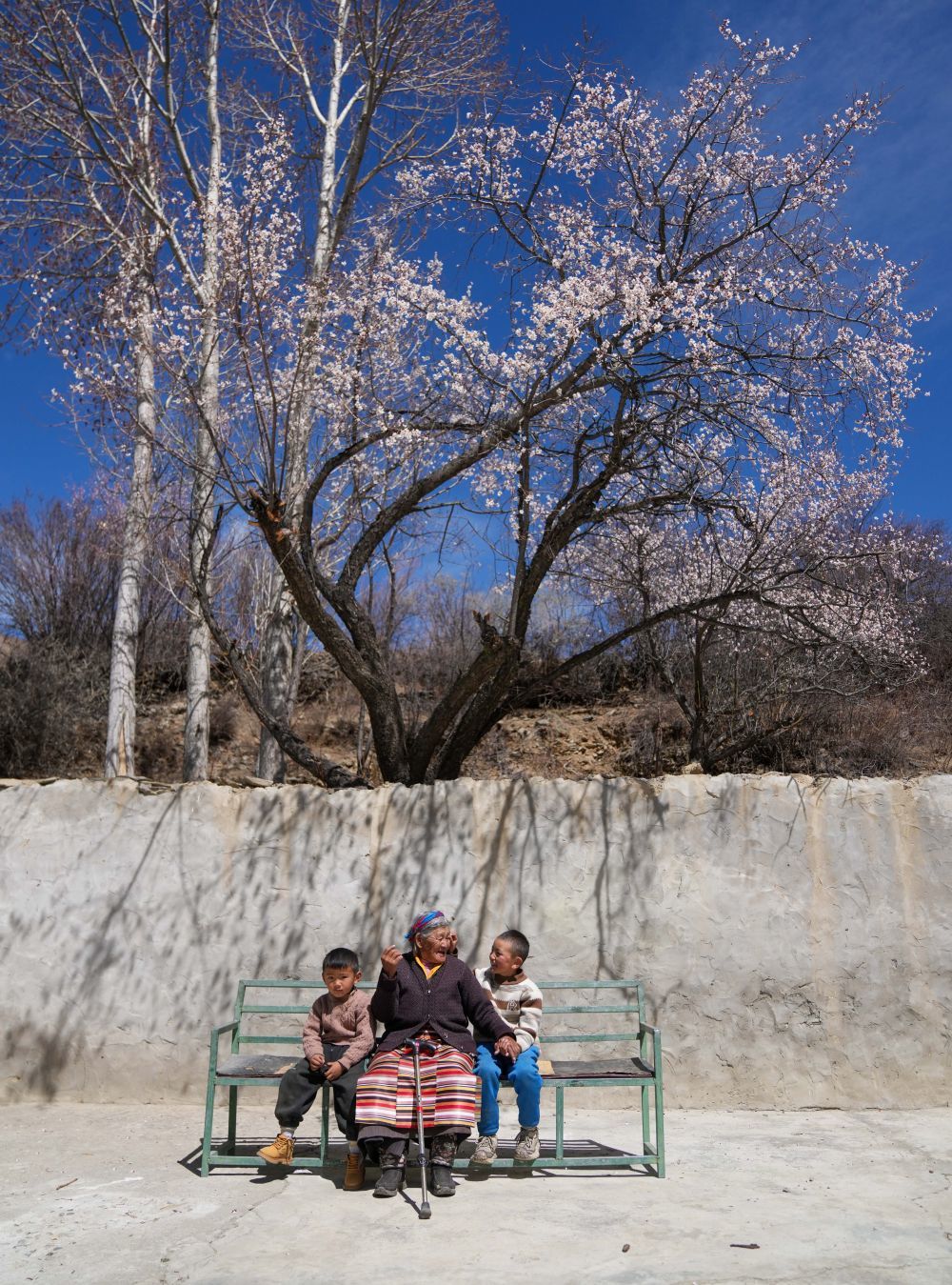 次仁桑姆(中)和两位晚辈在宗卡村家中的院子里聊天(3月26日摄)。