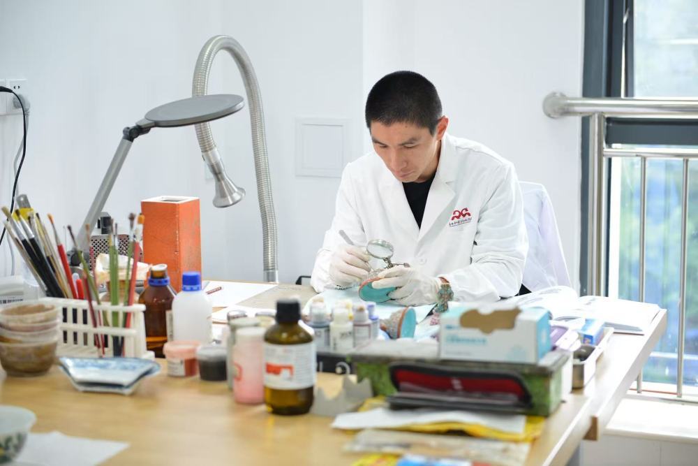 广西博物馆文物科技保护中心修复师陈琦在实验室修复文物。（广西壮族自治区博物馆供图）