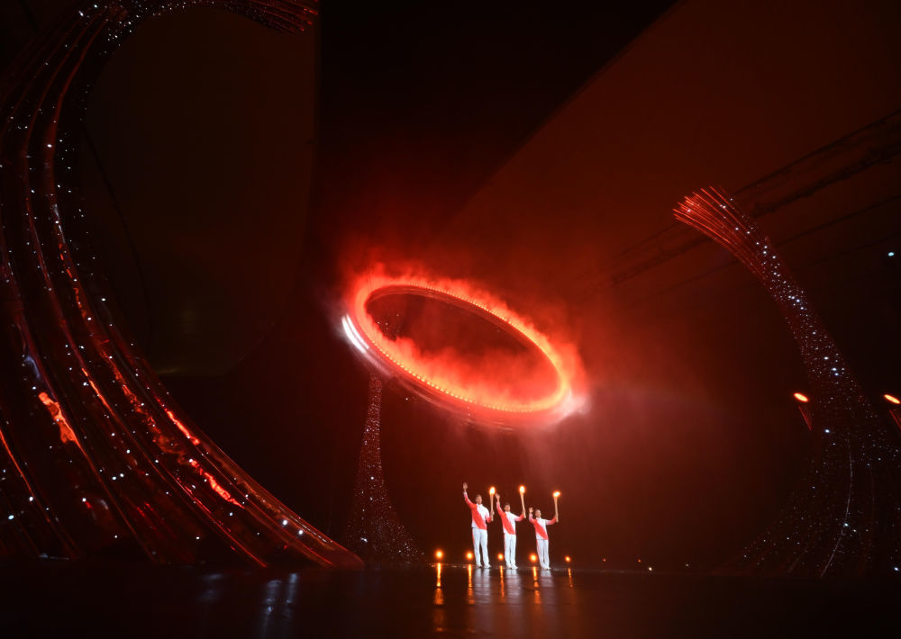 2025年11月9日,第十五届全国运动会开幕式在广东奥林匹克体育中心举行。这是火炬手苏炳添(中)、张家朗(左)、李祎点燃主火炬后向观众致意。新华社记者 肖艺九 摄