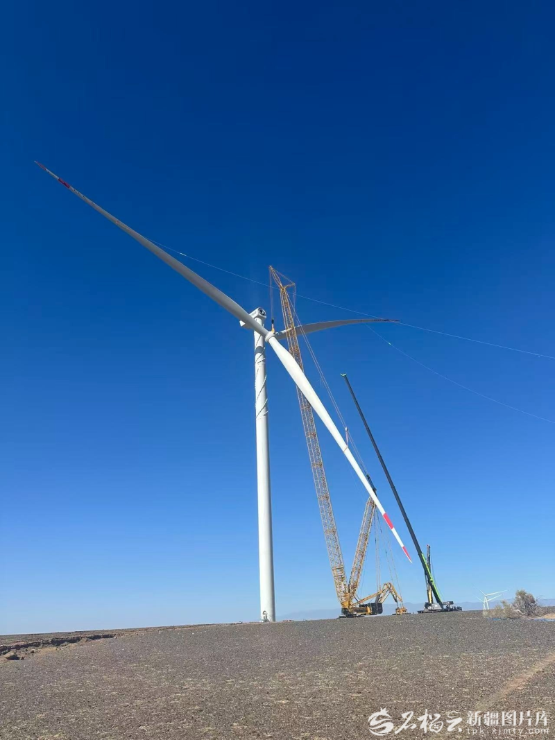 3月22日，其亚新疆集团有限公司在木垒哈萨克自治县大石头乡吊装风机。王海滨 摄