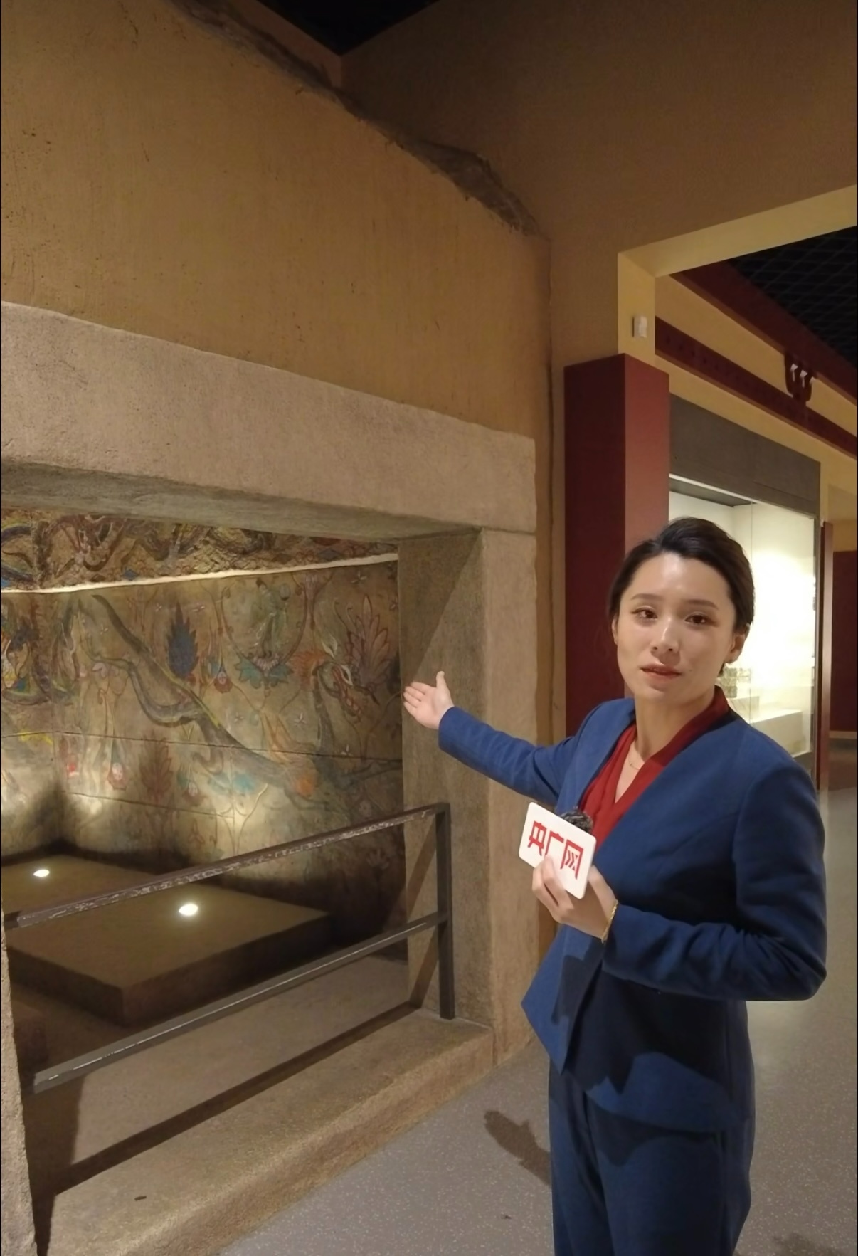 讲解员现场介绍“五盔坟4号墓壁画”(央广网记者 李雪 摄)
