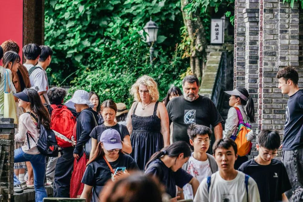 2026年7月,外籍游客在长江边的重庆市南岸区龙门浩老街游览。新华社发