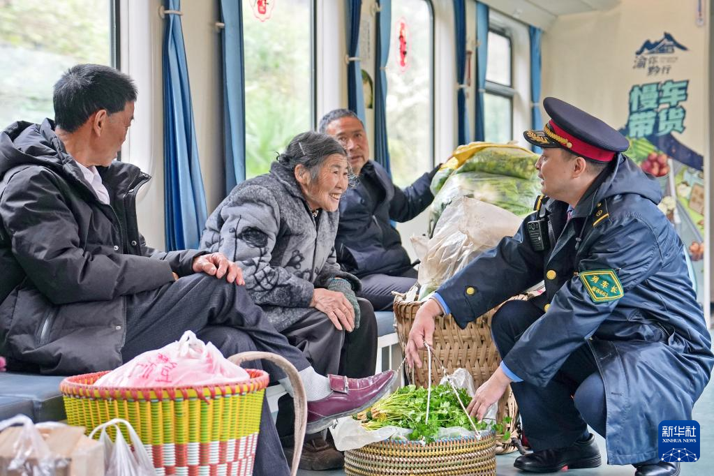 2月25日,村民们在5630次列车上和列车长交流。新华社发(张维 摄)