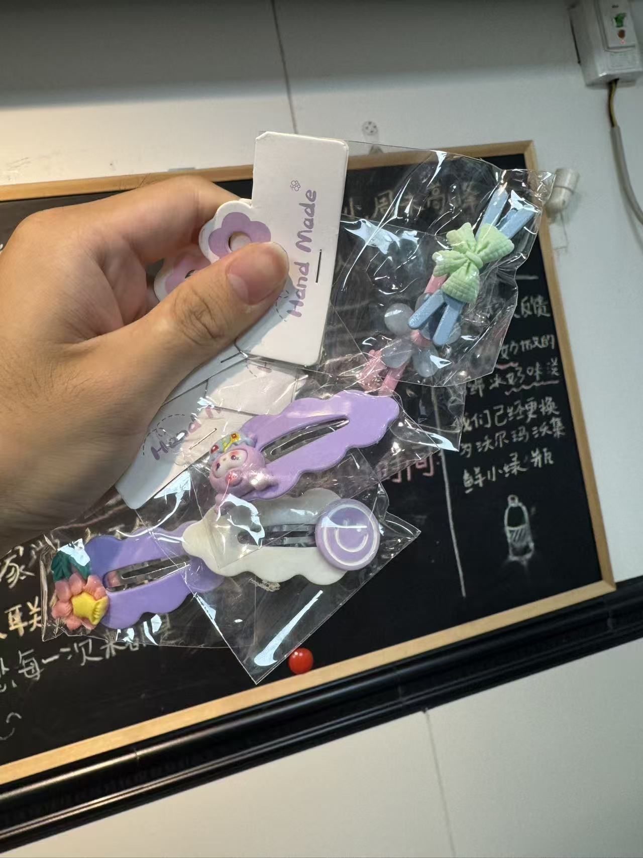 △店主向记者店内准备的驱蚊手环和发夹。