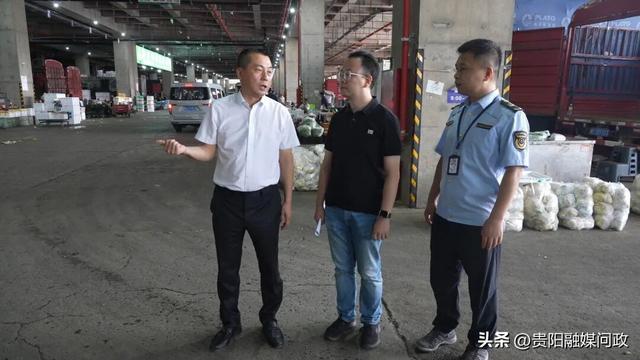 提案者代表、民革贵阳市直一支部主委周晓帆（中）查看贵阳地利农产品物流园园区情况