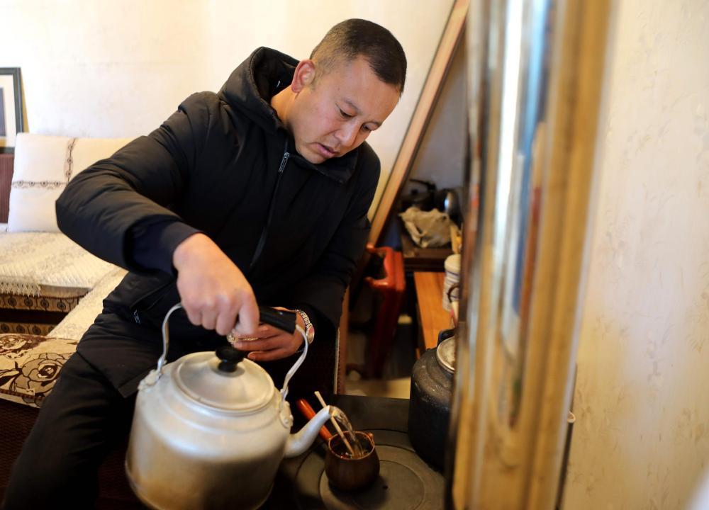 2月10日，元古堆村村民马海龙在家里煮罐罐茶。新华社记者 王朋 摄
