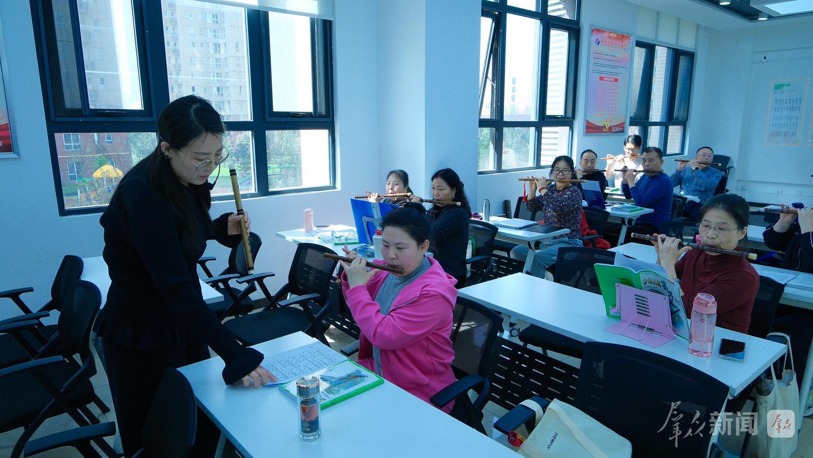 3月31日,群众在秦都区新时代文明实践中心学习吹笛子,体验文化活动。