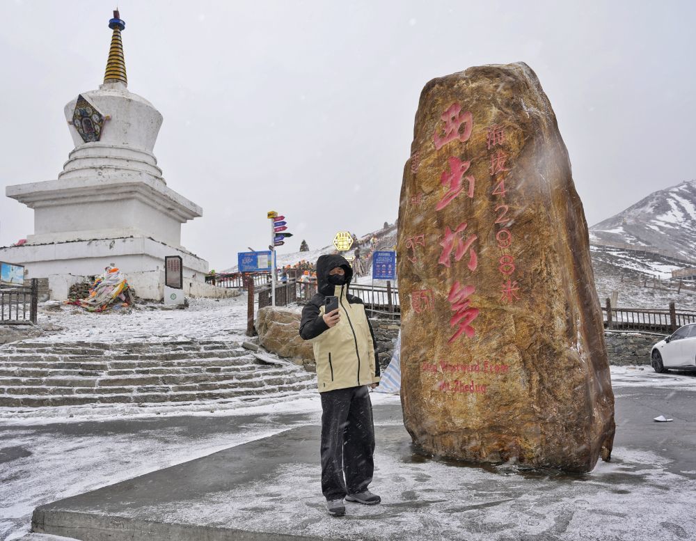 1月30日,游客正在折多山垭口处“西出折多”碑前打卡拍照。新华社记者刘坤 摄