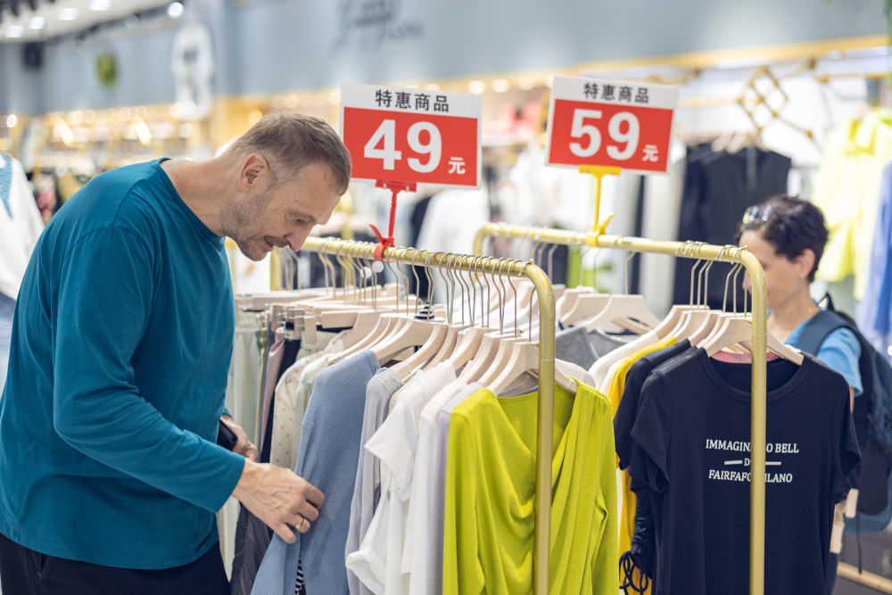 ↑ 4月22日，在重庆市渝中区新重庆国际小商品批发中心，来自德国的一对夫妇在选购衣服。