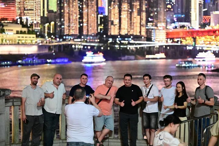7月10日，西班牙游客在重庆市南岸区南滨路自拍。新华社发（郭旭 摄）