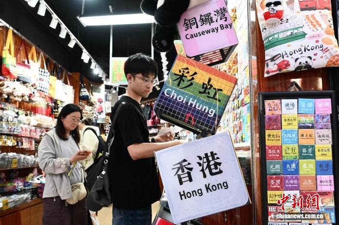 10月6日,内地国庆假期接近尾声,香港市面人气仍旺。图为游客在香港一家礼品店挑选特色商品。 中新社记者 李志华 摄
