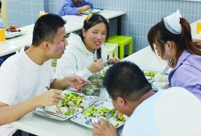 食堂里,张皓韦、闫浩然、赵馨、宋海莹4名队友一边用餐,一边交流板铃球训练情况。