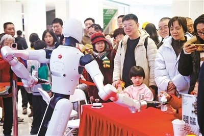 大年初一的北京2026大都新春庙会上,春晚同款机器人集体亮相,成为当之无愧的“顶流”。图为机器人在与观众互动供图/视觉中国