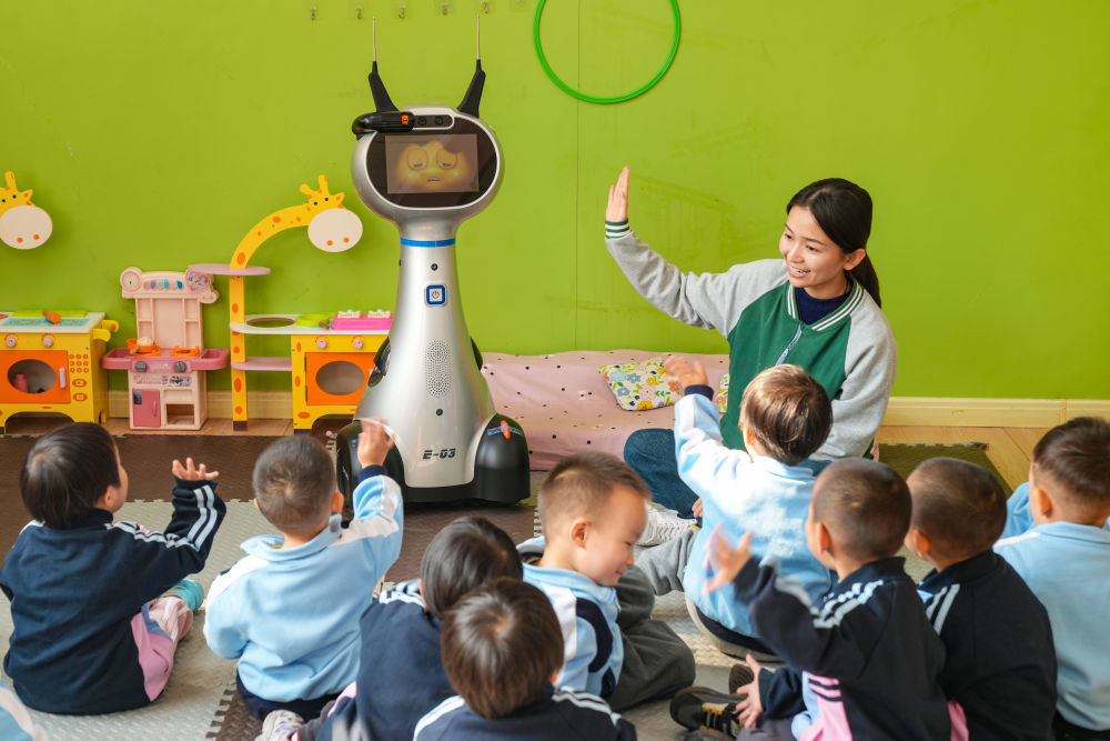 2025年11月4日，在山东省乐陵市天和嘉园幼儿园，老师带托育班的小朋友和机器人做互动。新华社发（贾鹏 摄）