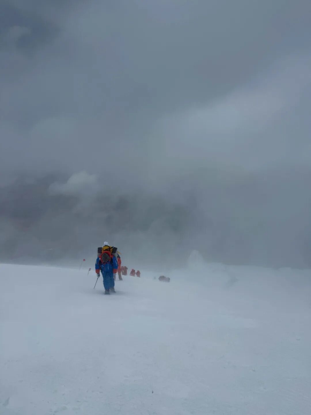 2026年7月，在慕士塔格峰的冲顶途中，登山者在风雪中前行。图/受访者提供