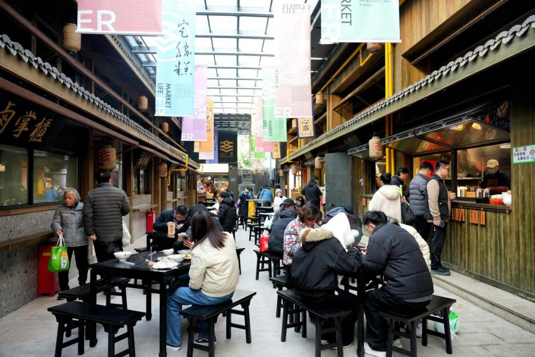 1月8日，市民游客在浙江省杭州市文二菜市的宋韵小吃街上品尝美食。新华网发
