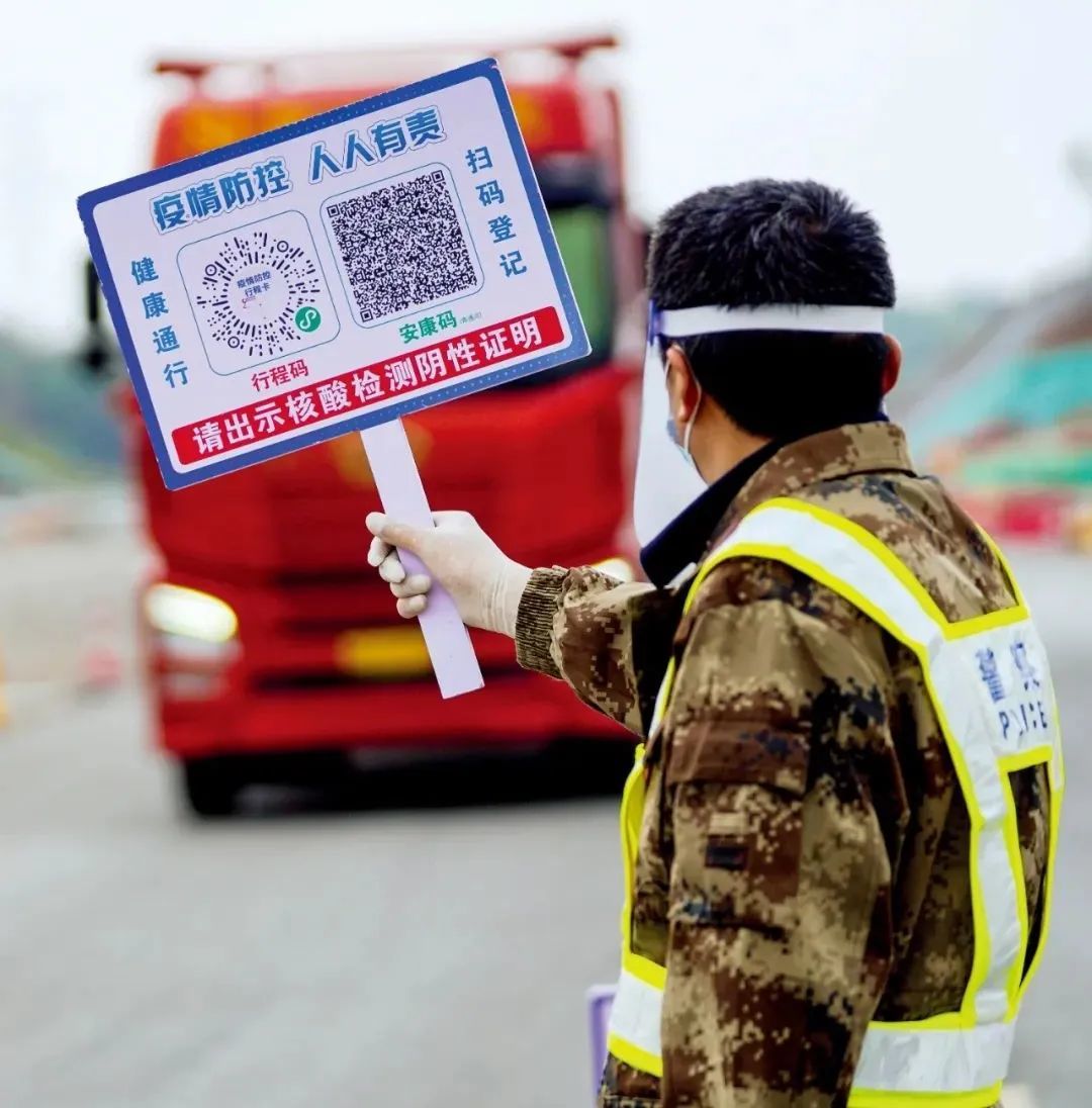 3月18日，安徽铜陵市郊区青通河交通卡点，值守人员手举标注了相关查验二维码的标识牌，对来往车辆开展排查。图/中新