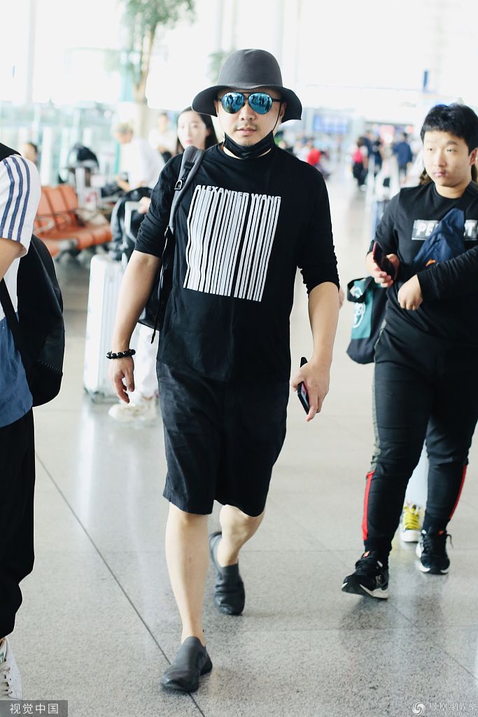 徐峥戴礼帽配墨镜现身机场 举手机拍粉丝化身呆萌大叔