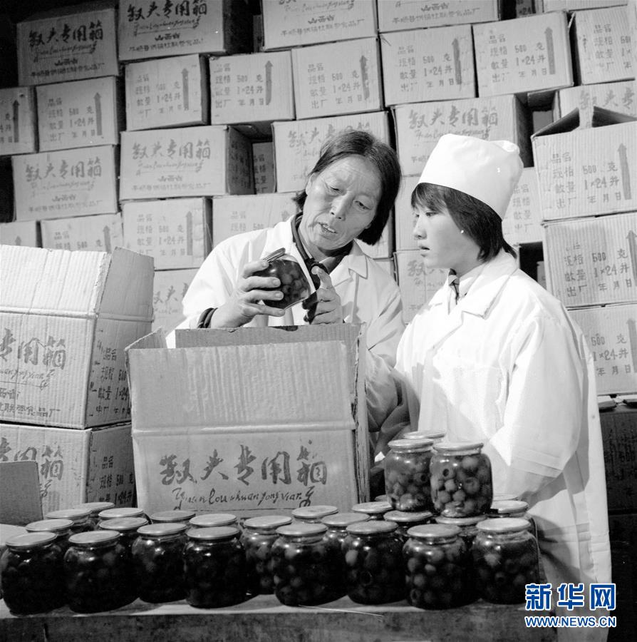 申纪兰带领群众脱贫致富，1986年9月与县供销社联合办起一座罐头厂，投产后的第一个月就生产红果、梨罐头5万多瓶。这是申纪兰（左）和工人一起检查罐头质量（资料照片）。 新华社发