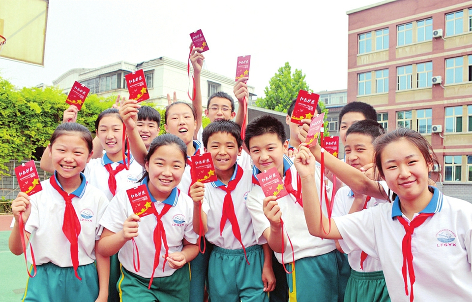 小学生展示爱国主义教育基地“红色护照”。