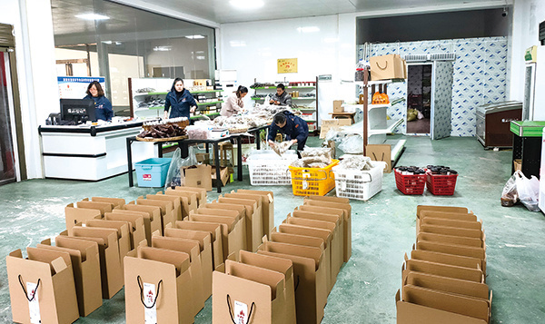 ("围山公社"的工作人员正在对农产品进行分拣打包.