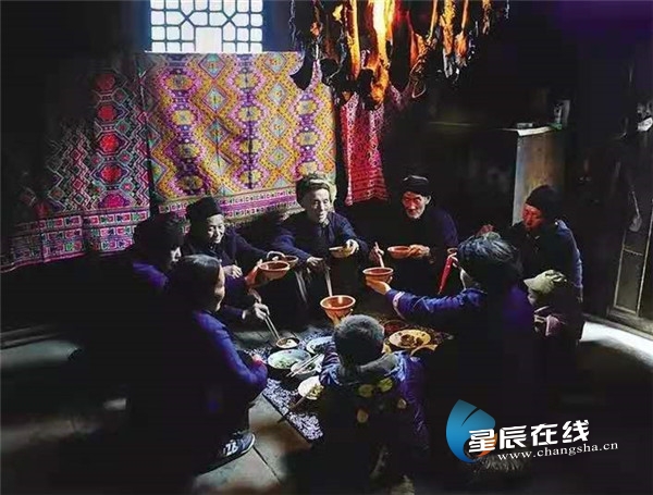 （土家族过年，欢聚火炕边。卢瑞生 摄）