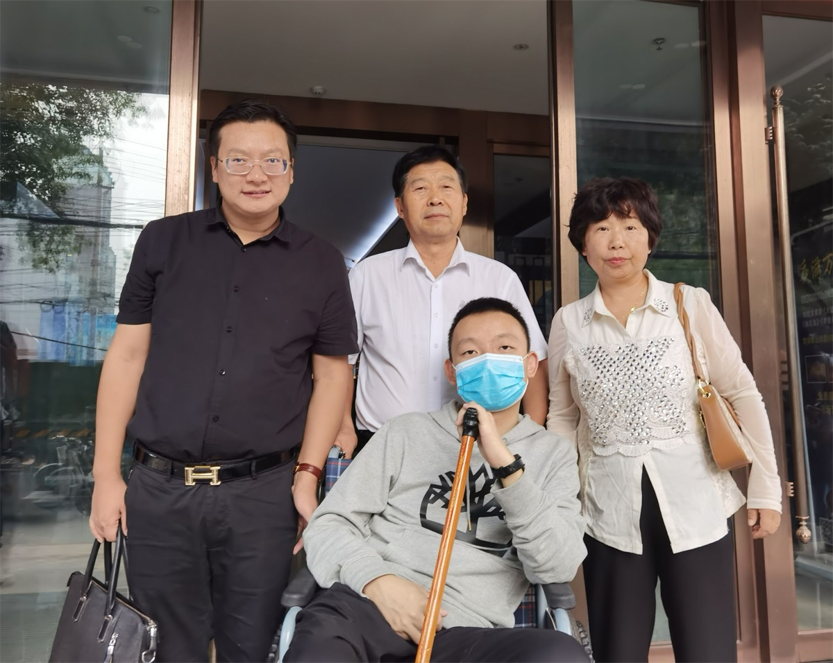 姚策及其亲生父母与律师周兆成合影.受访者供图