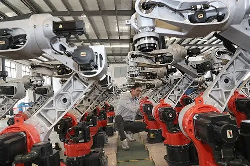 2020年5月24日,江苏南通一家工厂技术人员在机器人待测区调节皮带张力。
