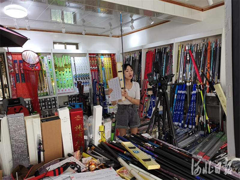 肃宁县西乾泊村村民郭小随正在抖音上直播卖鱼竿。 河北日报记者 戴绍志摄