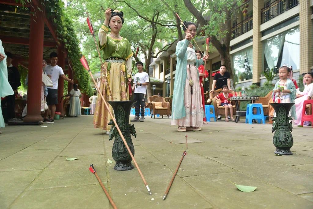 四川内江,汉服爱好者正在体验投壶游戏.