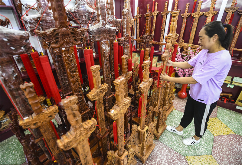 7月15日，在深州市一家桃木文化公司，工作人员整理桃木工艺品。