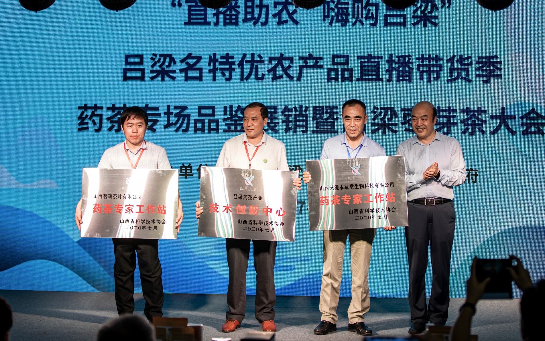 山西省科协党组成员、副主席郝建新（右一）为吕梁“一个中心、两个工作站”授牌