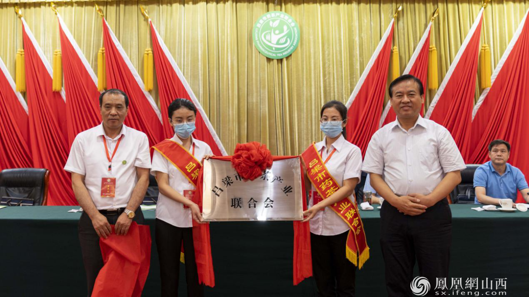 吕梁市政府副市长尉文龙（右一）和新当选理事长为吕梁市药茶产业联合会揭牌