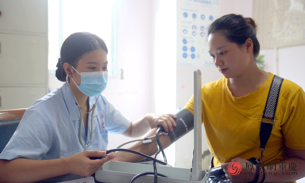 姚素鑫正在为病人测量血压。