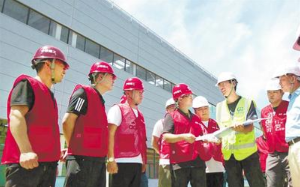 日前，满城区相关部门工作人员身穿红马甲，在河北京车项目建设现场进行协调服务。 河北日报通讯员 赵大鹏摄