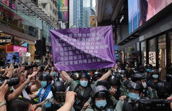 香港警察手持紫旗警告 图自港媒