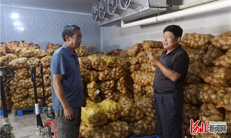 7月27日，郑林亭（右）到村民张福存的农产品仓储保鲜冷链库，询问收购情况。河北日报记者 尹翠莉 摄