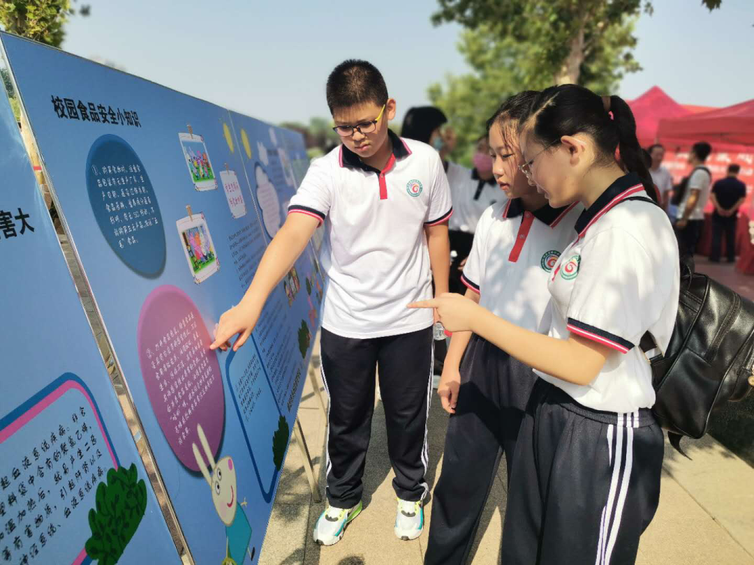 活动现场学生们认真讨论学习展板上的内容。