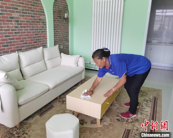 图为村民在家门口的窑洞宾馆内打工。　李洋 摄