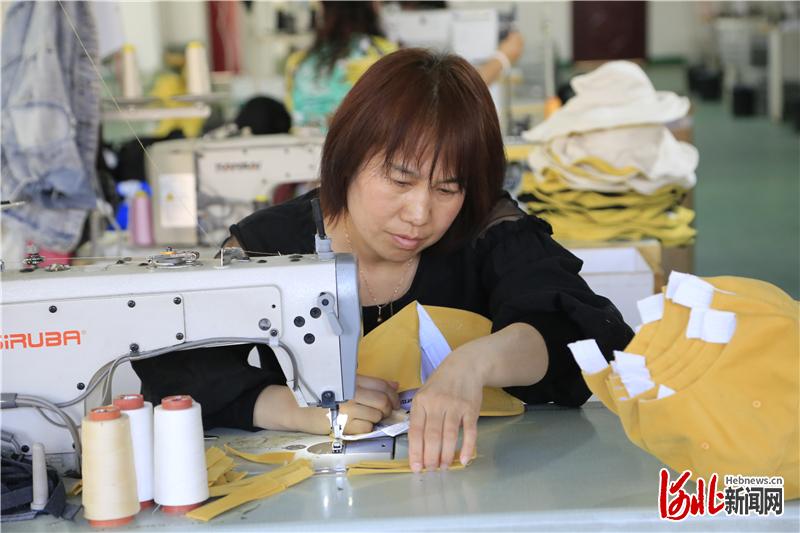 阜平县河口易地扶贫搬迁安置区的村民正在手工业扶贫车间加工帽子。通讯员 李秀芹摄