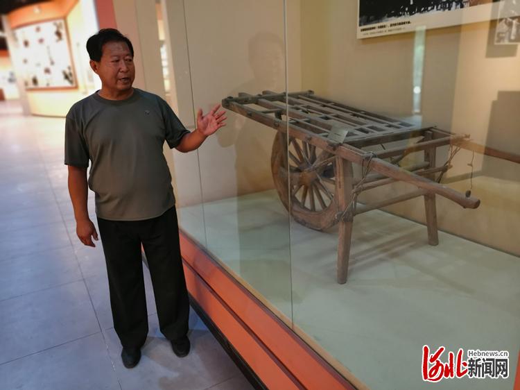 在马本斋纪念馆，馆长哈光杰站在展品木制小推车前，讲述马本斋烈士大义爱国和马母宁死不屈的感人事迹。 河北日报记者戴绍志摄