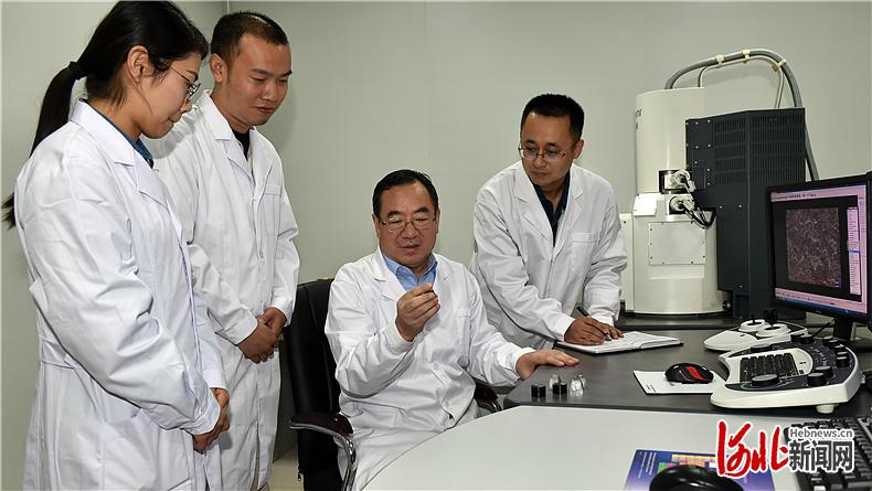 王新东（左）与研发团队成员就高强钢显微组织转变机理进行交流。（河北日报资料片） 河北日报记者田瑞夫摄