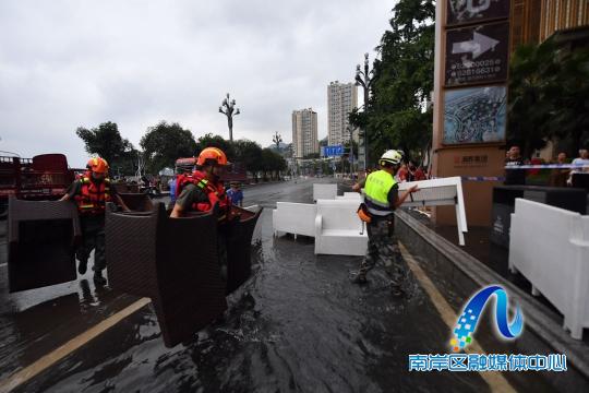 南岸区应急局救援队员协助商家搬运物资尽快撤离危险水域。