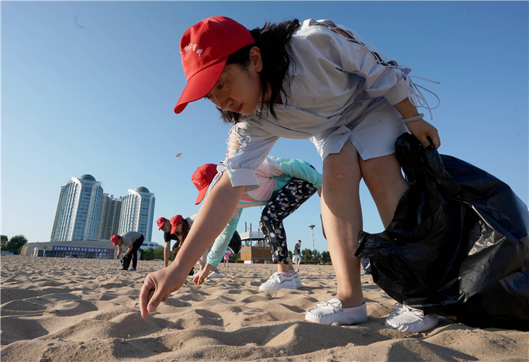 8月21日,秦皇岛市民在金梦海湾浴场捡拾杂物.